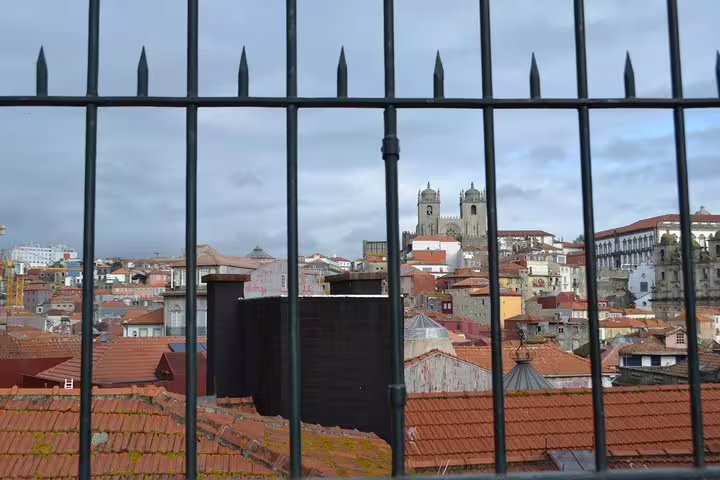 Scenic view of Porto's historic rooftops and cathedral from a gated vantage point on the Jewish Heritage Walking Tour.
