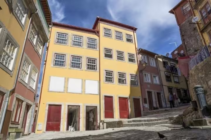 Charming colorful buildings line a steep cobblestone street in Porto's historic Jewish Quarter.