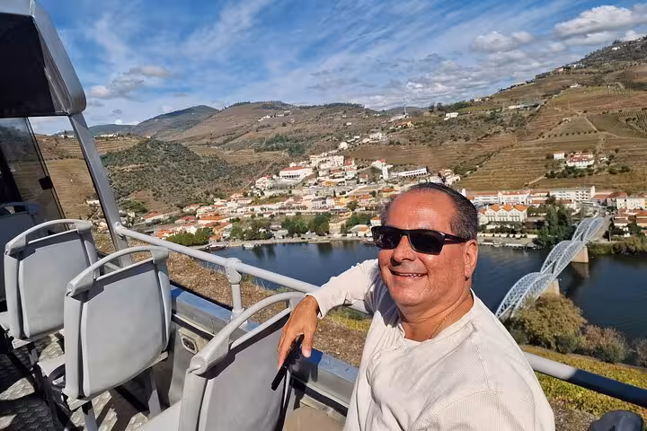 Traveler enjoying Douro River viewpoint near Peso da Régua on private Porto to Lisbon via Douro Valley tour
