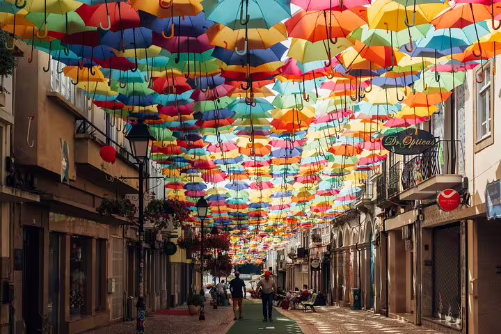 Vibrant umbrella display in Águeda, Portugal, a colorful attraction on the private transfer tour from Porto to Lisbon.