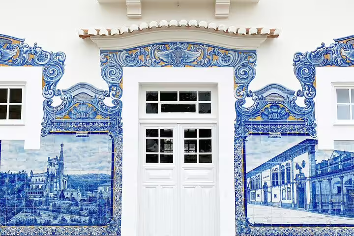 Beautiful azulejo tiles on a building facade in Portugal, showcasing cultural highlights on the Porto to Lisbon journey.