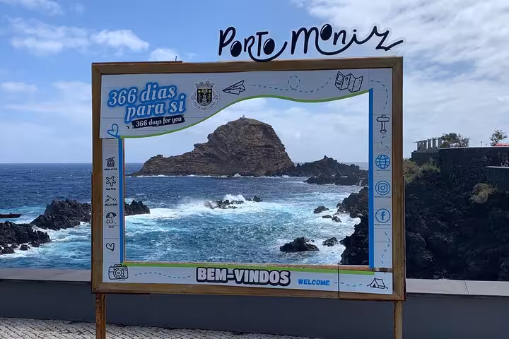 Porto Moniz coastal view framed by a welcome sign highlighting The Untraveled West Tour.