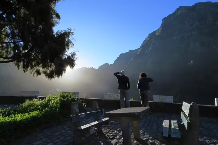 Travelers enjoy a breathtaking sunrise view over Porto Moniz cliffs, capturing the essence of a full-day local tour experience.