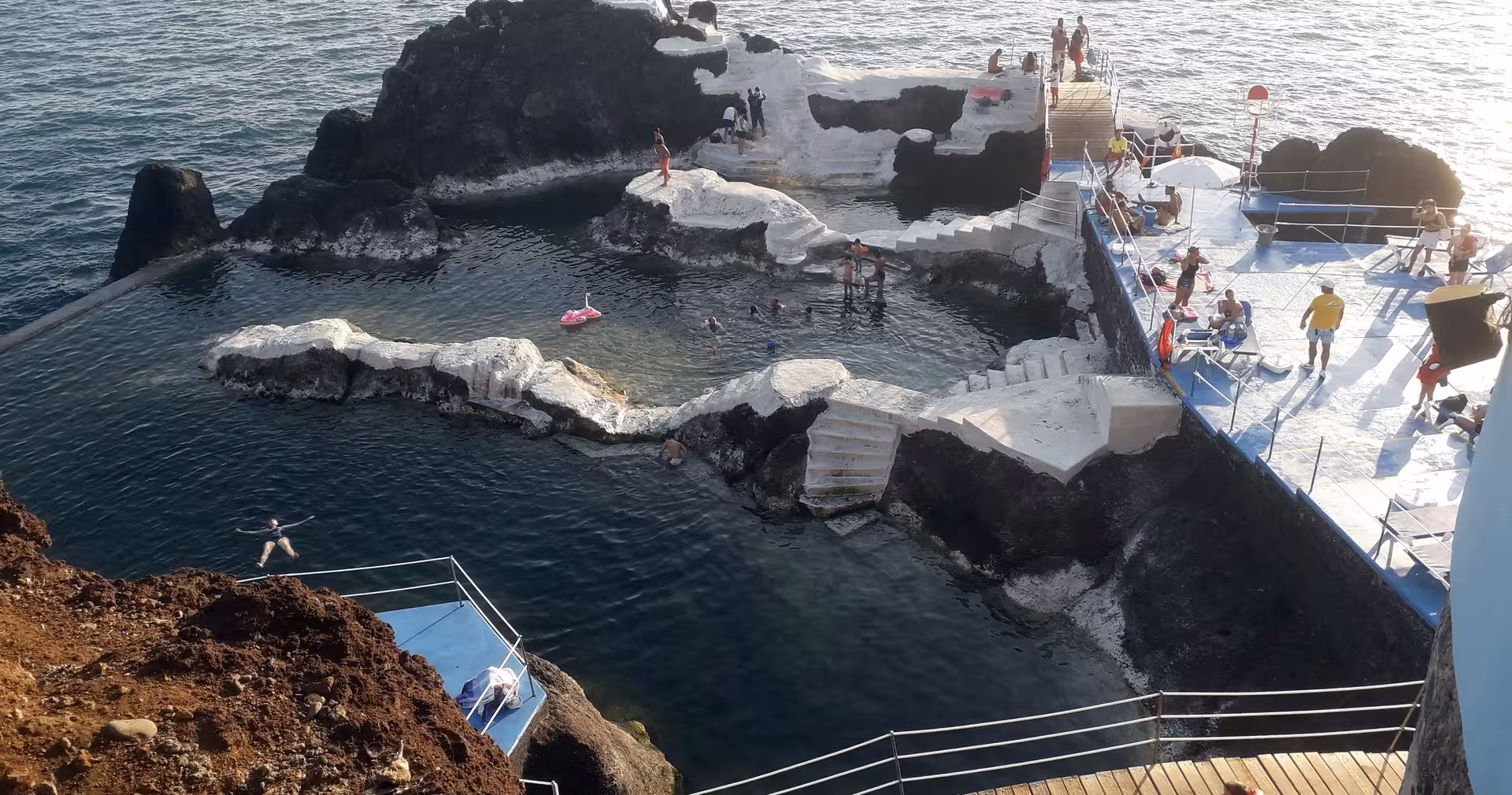 Volcanic natural pools at Porto Moniz, Madeira, with swimmers and sea views, featured on the 4-day island tour