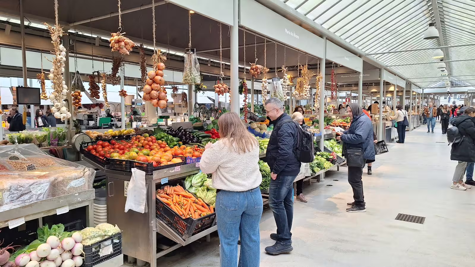 Visitors explore vibrant fresh produce at Porto's local market during a guided morning tour, showcasing authentic culinary culture.