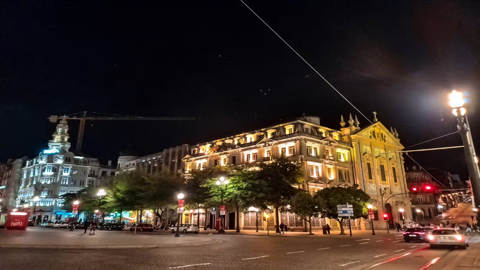 Night view of Porto's iconic illuminated architecture on a private city tour, showcasing vibrant streets and historic buildings.