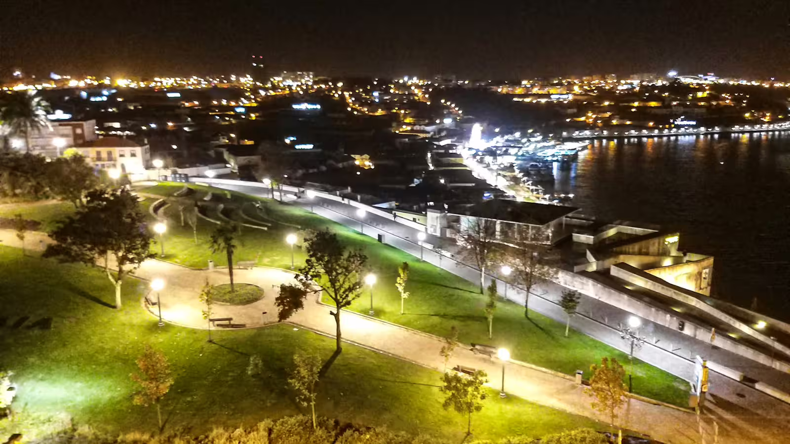 Night view of Porto's illuminated riverside park and cityscape, showcasing the vibrant atmosphere of the private night tour.