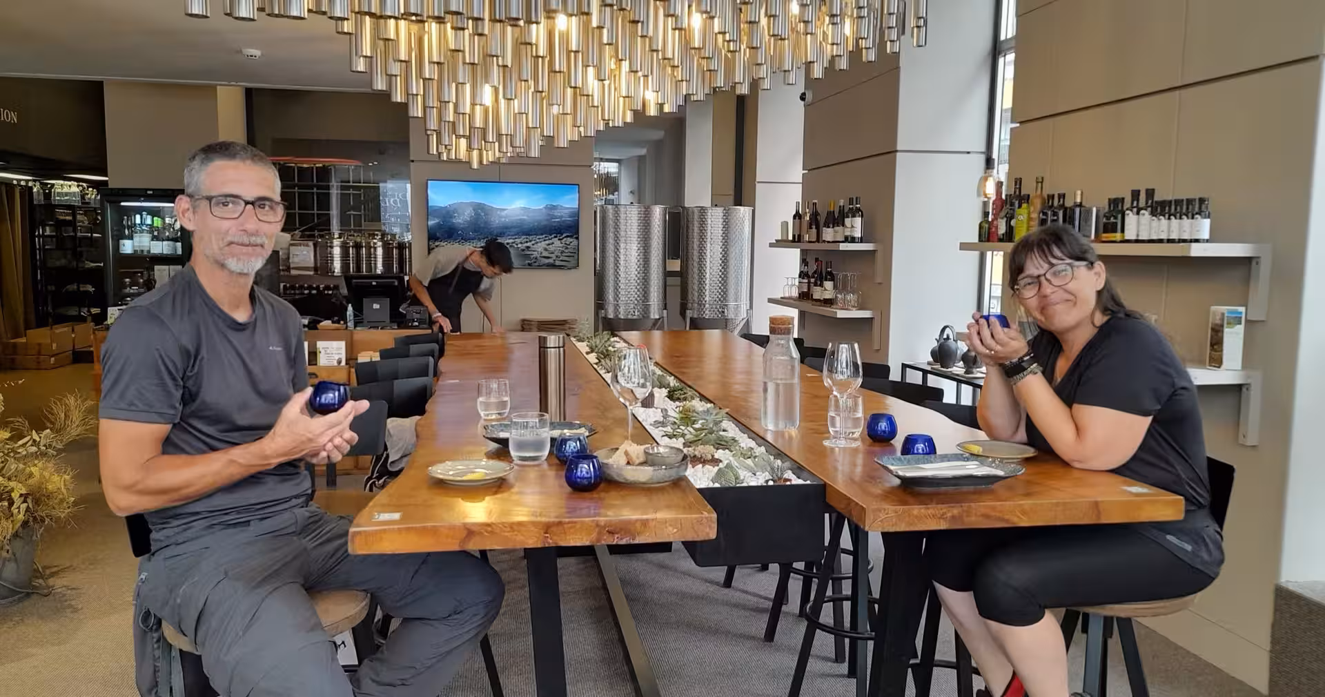 Guests sampling olive oil in blue cups at a Porto tasting bar during guided olive oil tasting experience