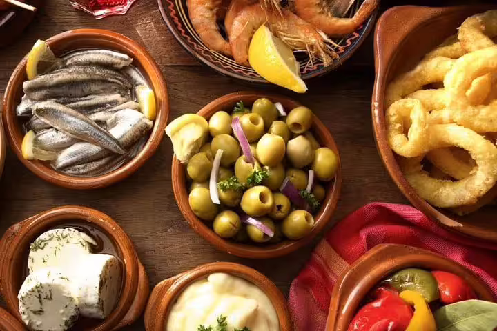 An assortment of Portuguese tapas including olives, cheese, seafood, and vegetables served on a day cruise from Porto.