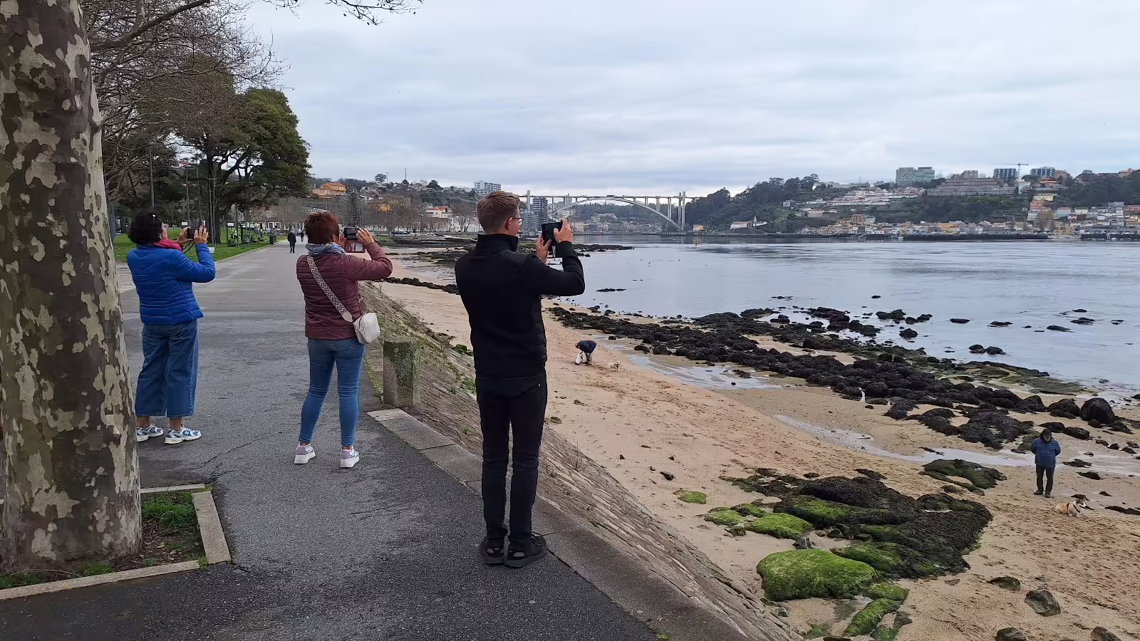 Tourists capture scenic views of the Douro River and Arrábida Bridge during a private morning tour in Porto.
