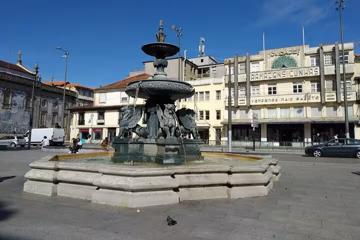 Historic fountain in a bustling square in Porto offers a glimpse into local culture for private tour groups of 1 to 8 people.