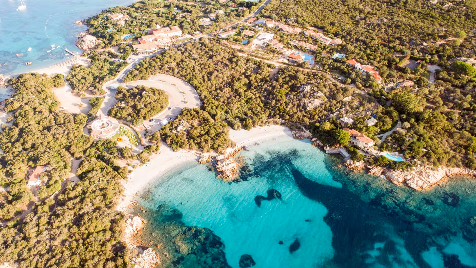Aerial view of Porto Rotondo's coastline with turquoise waters and lush greenery, ideal for boat tours in Sardinia.