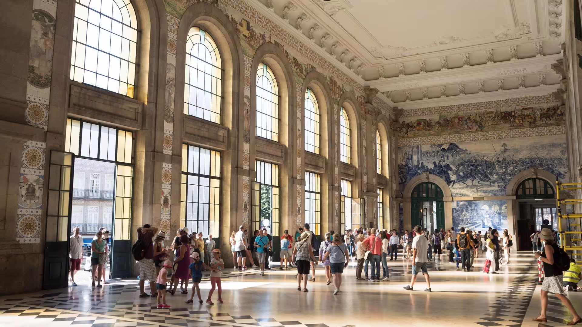 Tourists admire the stunning azulejo tiles inside Porto's São Bento Railway Station during a private city tour.