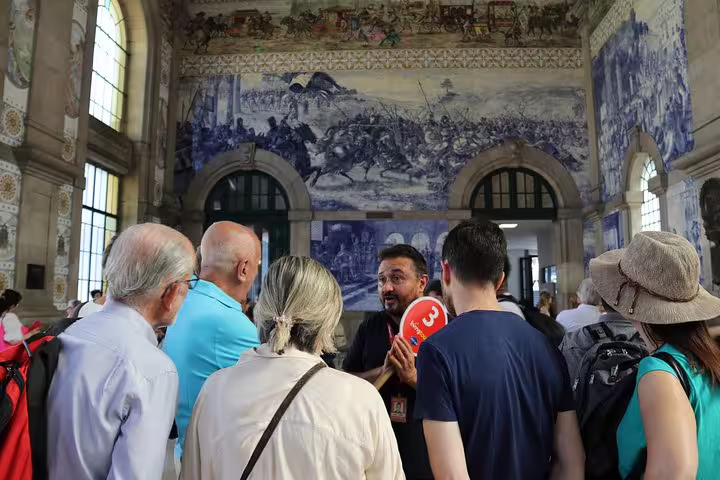 Tour group exploring the historic São Bento Railway Station in Porto with stunning azulejo tile murals.