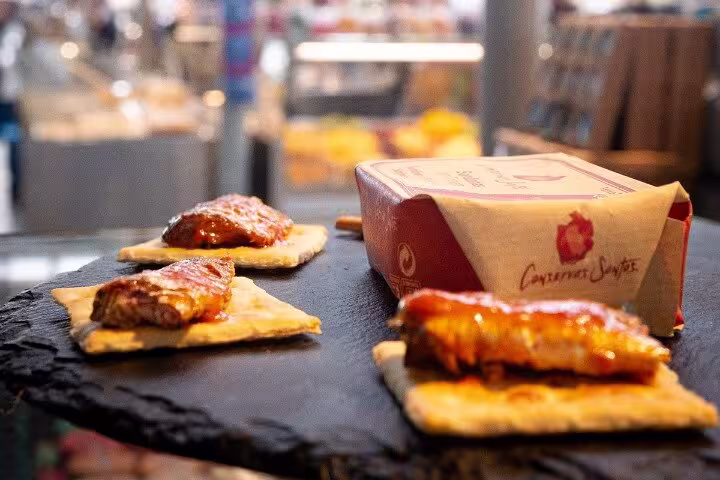 Sardines on crackers with gourmet packaging at a Porto market food tour experience.
