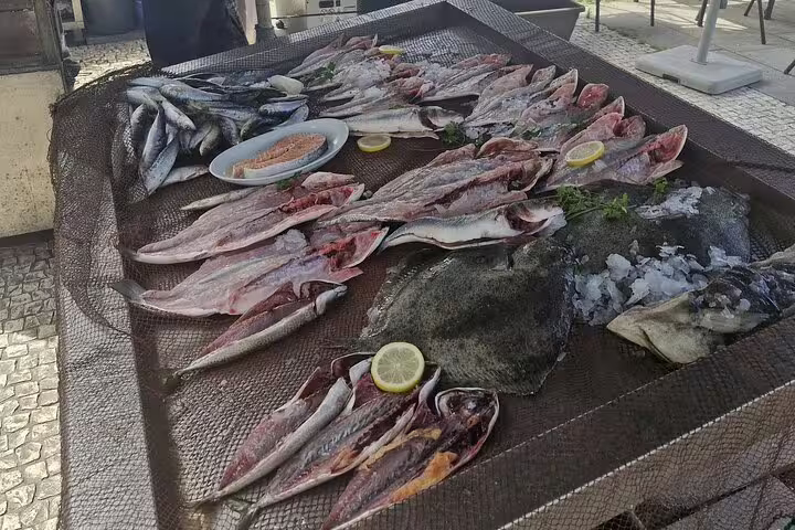 Fresh seafood display featuring fish and lemon slices, highlighting a delicious seafood lunch in Porto.