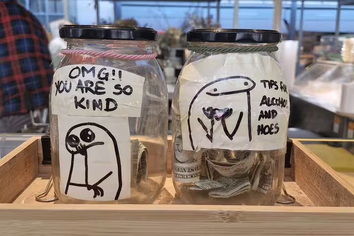Quirky tip jars with humorous labels in a Porto seafood restaurant, adding charm to the dining experience.