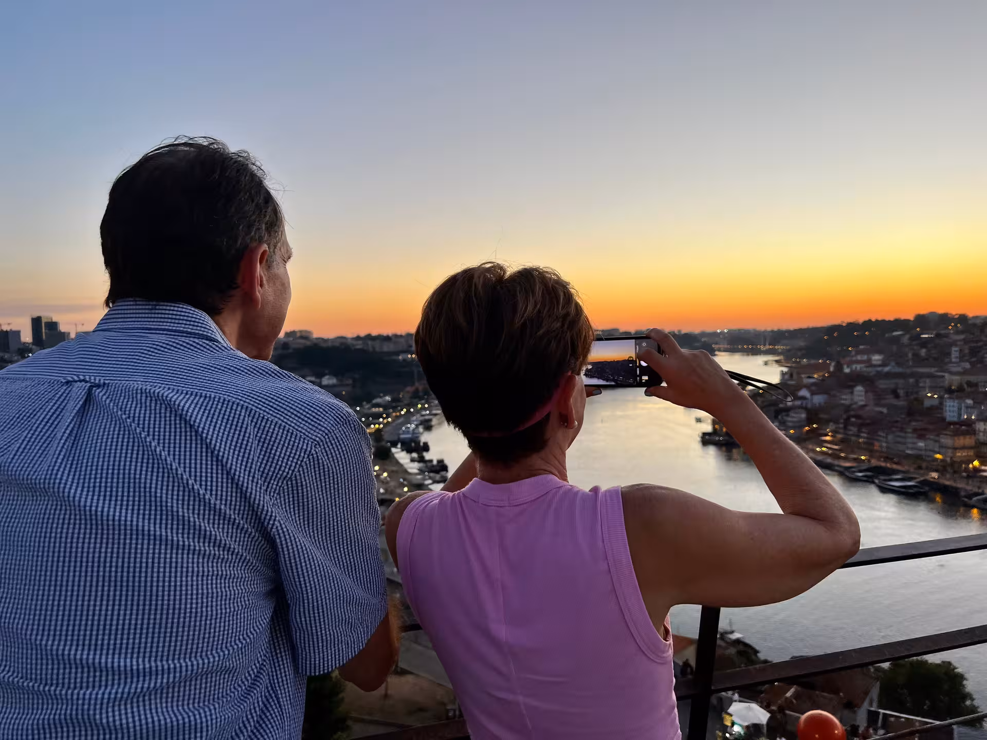 Travelers photograph Porto sunset over the Douro River from a viewpoint on the Sunset Tour of Porto