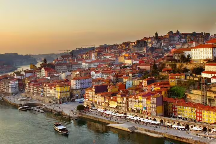 Stunning view of Porto's colorful riverside buildings at sunset, perfect for a Port wine rooftop experience.