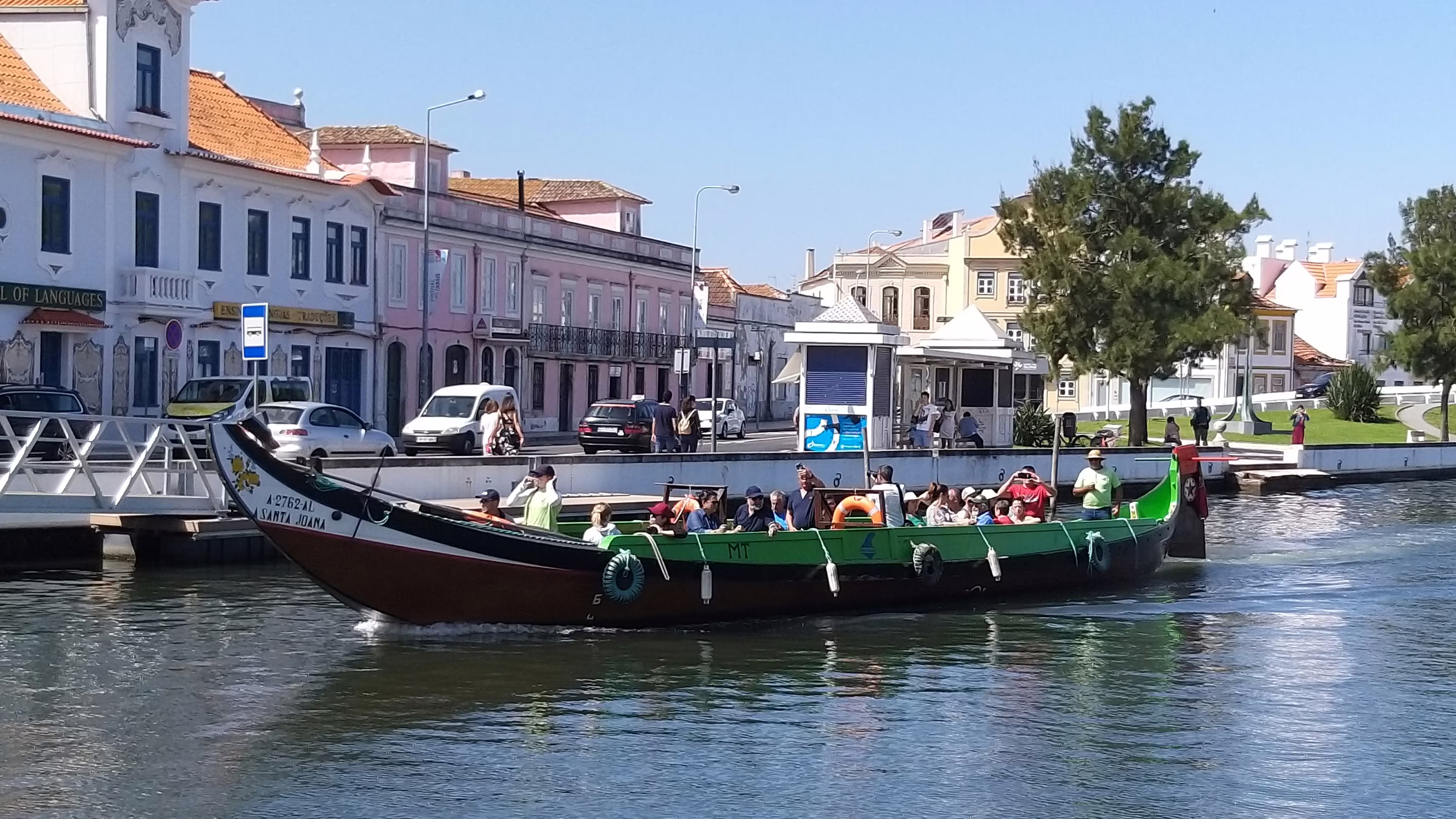 Tourists enjoying a scenic boat ride along the canals of a charming Portuguese town, capturing local culture.