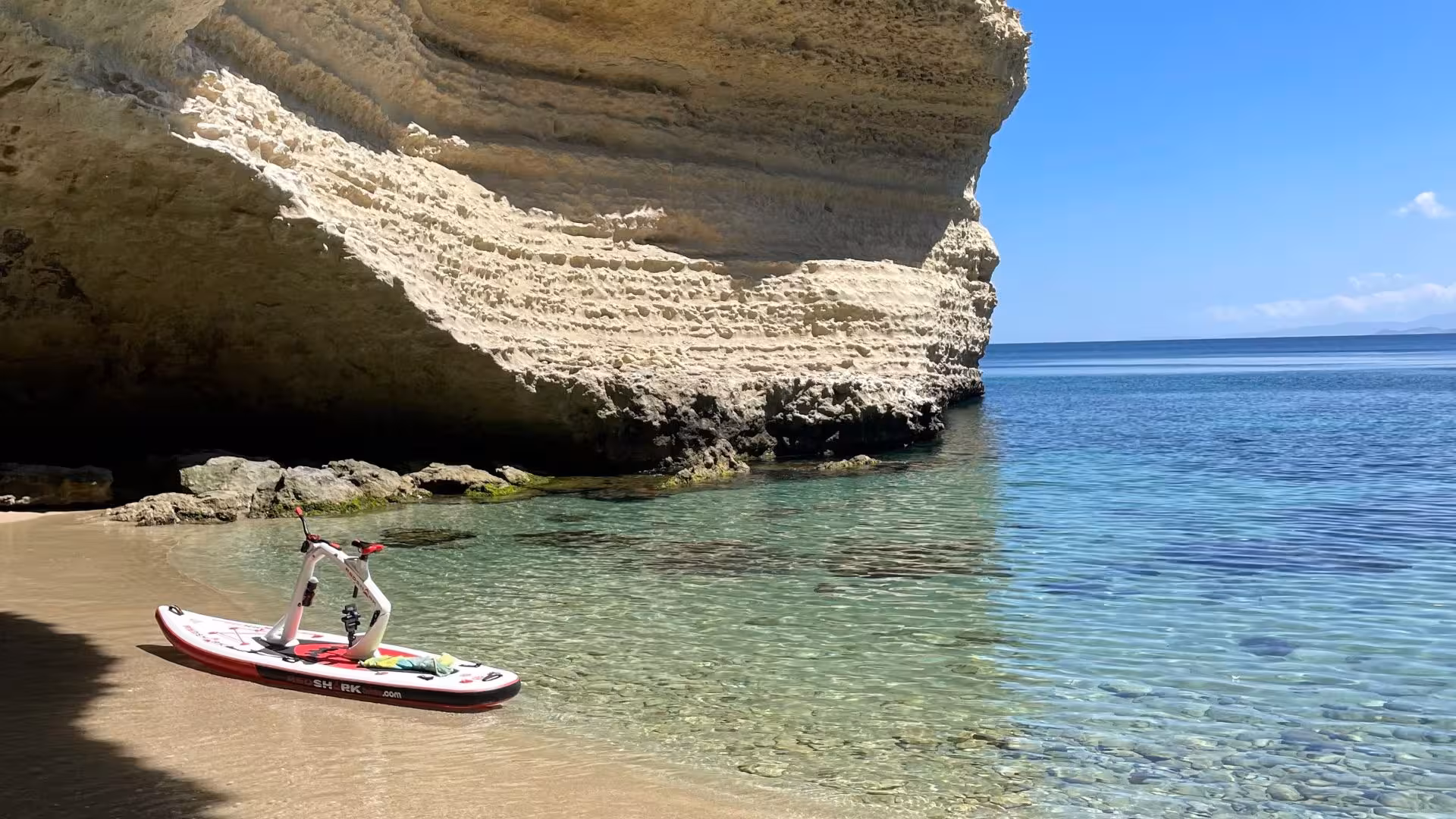 Water bike parked on a pristine beach with crystal clear waters and rocky cliffs in Porto Torres.