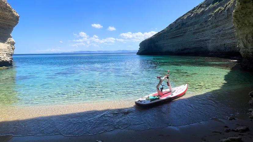 Scenic Porto Torres cove with a water bike ready for an adventurous sea tour under clear blue skies.