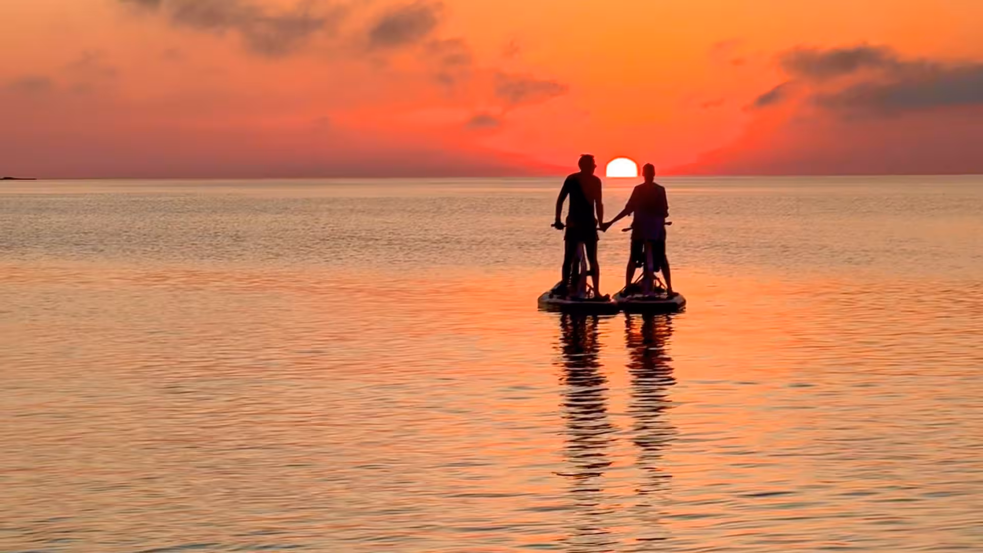 Couple enjoying a romantic water bike ride at sunset on Porto Torres tour.