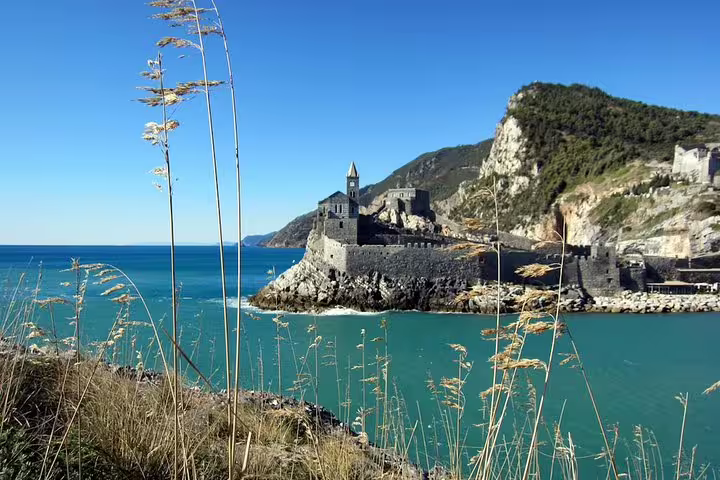 Historic seaside church at Porto Venere framed by wild grasses, captured on a sunny private tour of Italy’s Gulf of Poets