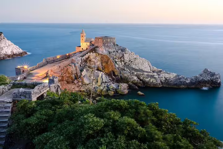 Sunset view of Porto Venere church on a rocky promontory, overlooking turquoise Ligurian Sea on a private Gulf of Poets tour