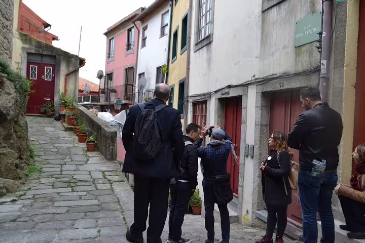Tourists exploring Porto's charming alleys with colorful houses on an essential walking tour.