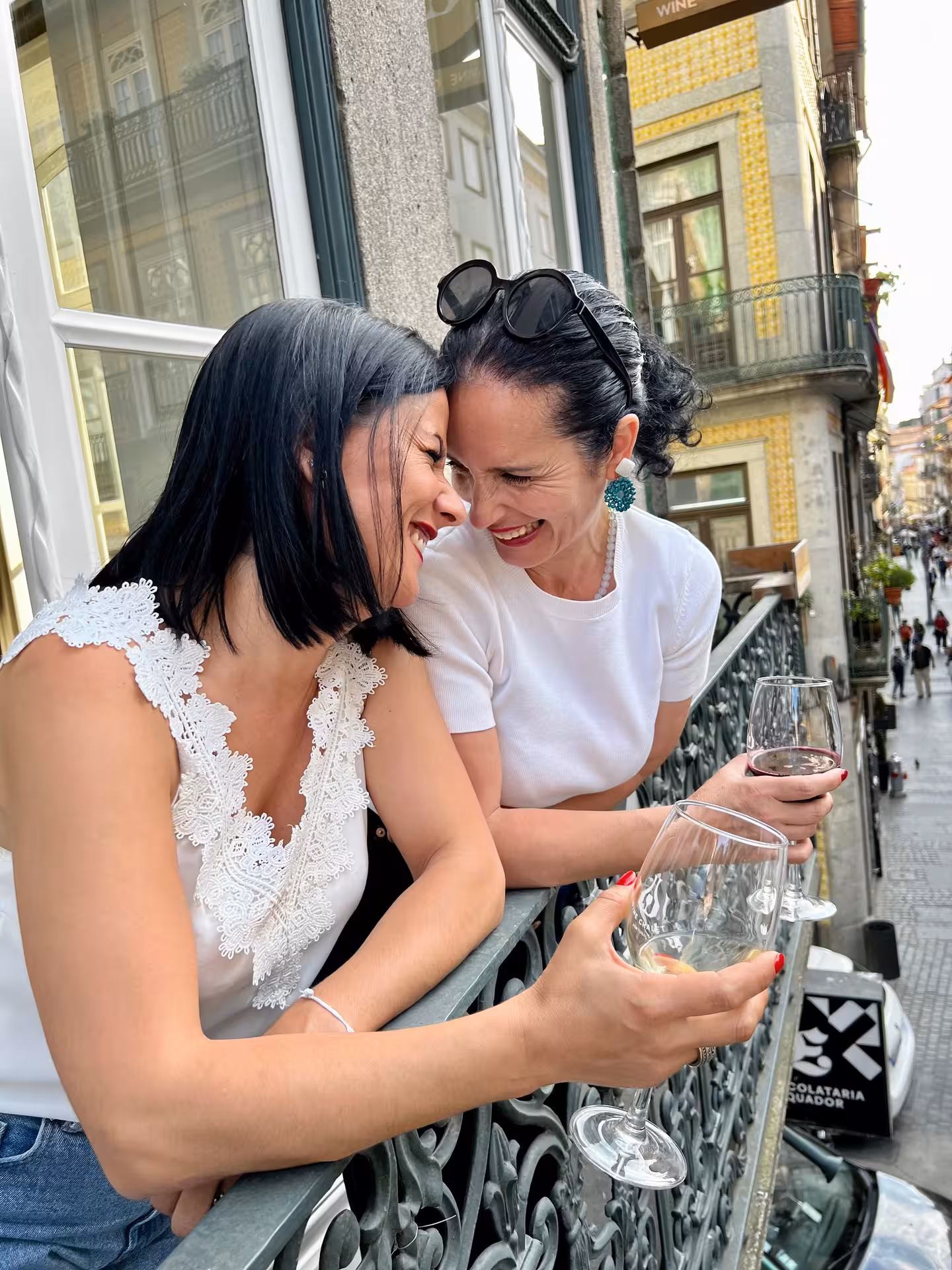 Friends sipping wine on a Porto balcony, perfect for Not Port! wine tour tastings in downtown Porto