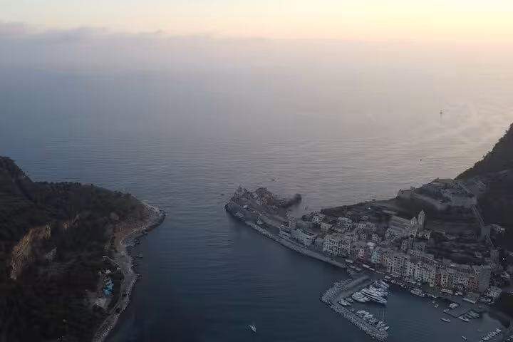 Sunset view of Portovenere's charming harbor with colorful buildings lining the waterfront, ideal for a boat tour.