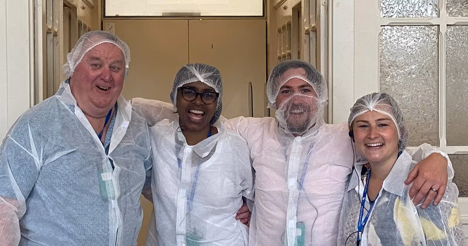 Guests in hairnets and lab coats during a Portuguese cooking class on the 8-day Portugal food and wine tour