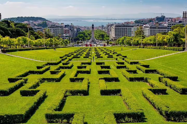 Stunning view of Eduardo VII Park's geometric hedges leading to Lisbon's skyline, perfect for a Portugal tour from Lisbon.