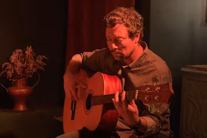 Solo guitarist immersed in playing Fado music at an intimate Lisbon concert, highlighting Portuguese traditions.