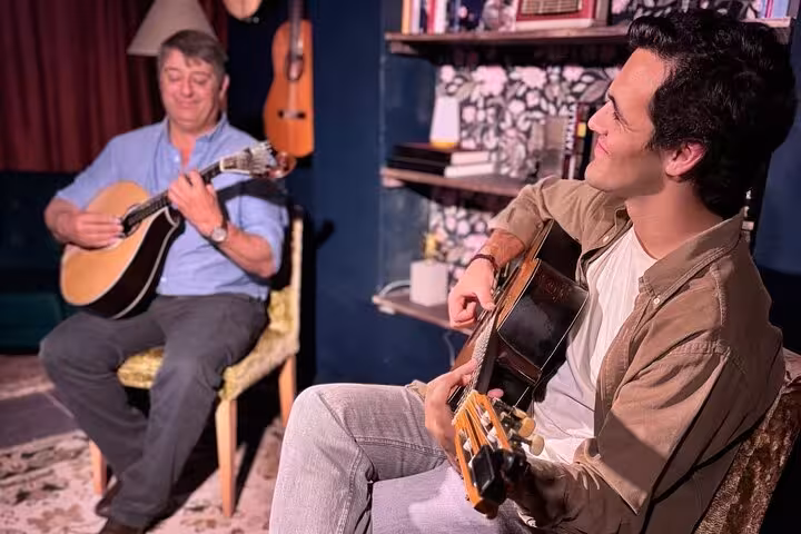 Two musicians perform traditional Fado music in a warm, inviting Lisbon venue.