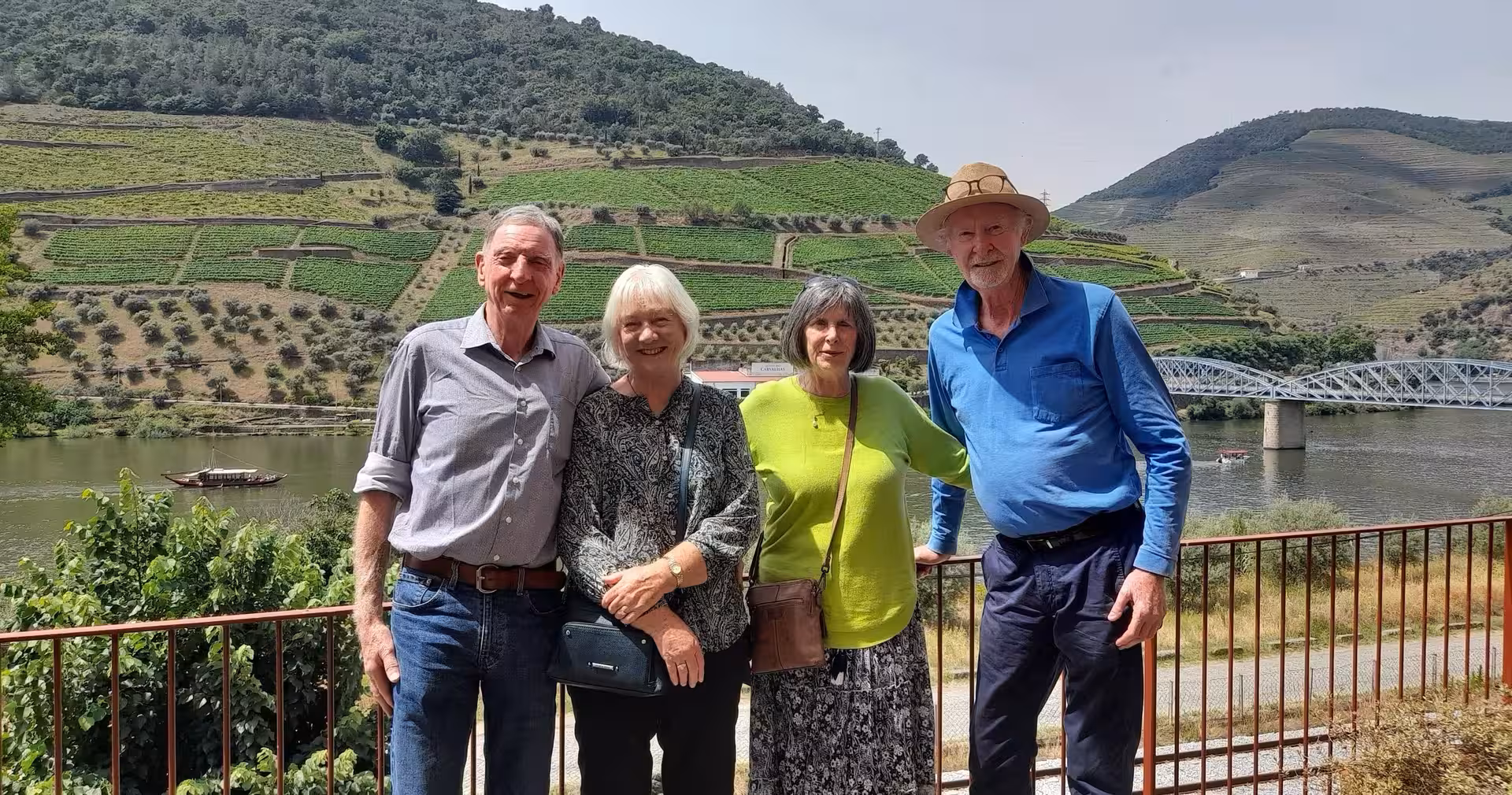 Travelers pose by Douro River terraces and bridge, a highlight on the 7-day Portugal tour Lisbon to Porto