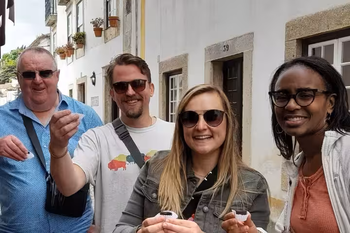 Travelers tasting Portuguese wine on a village street during an 8-day Portugal food and wine tour with classes