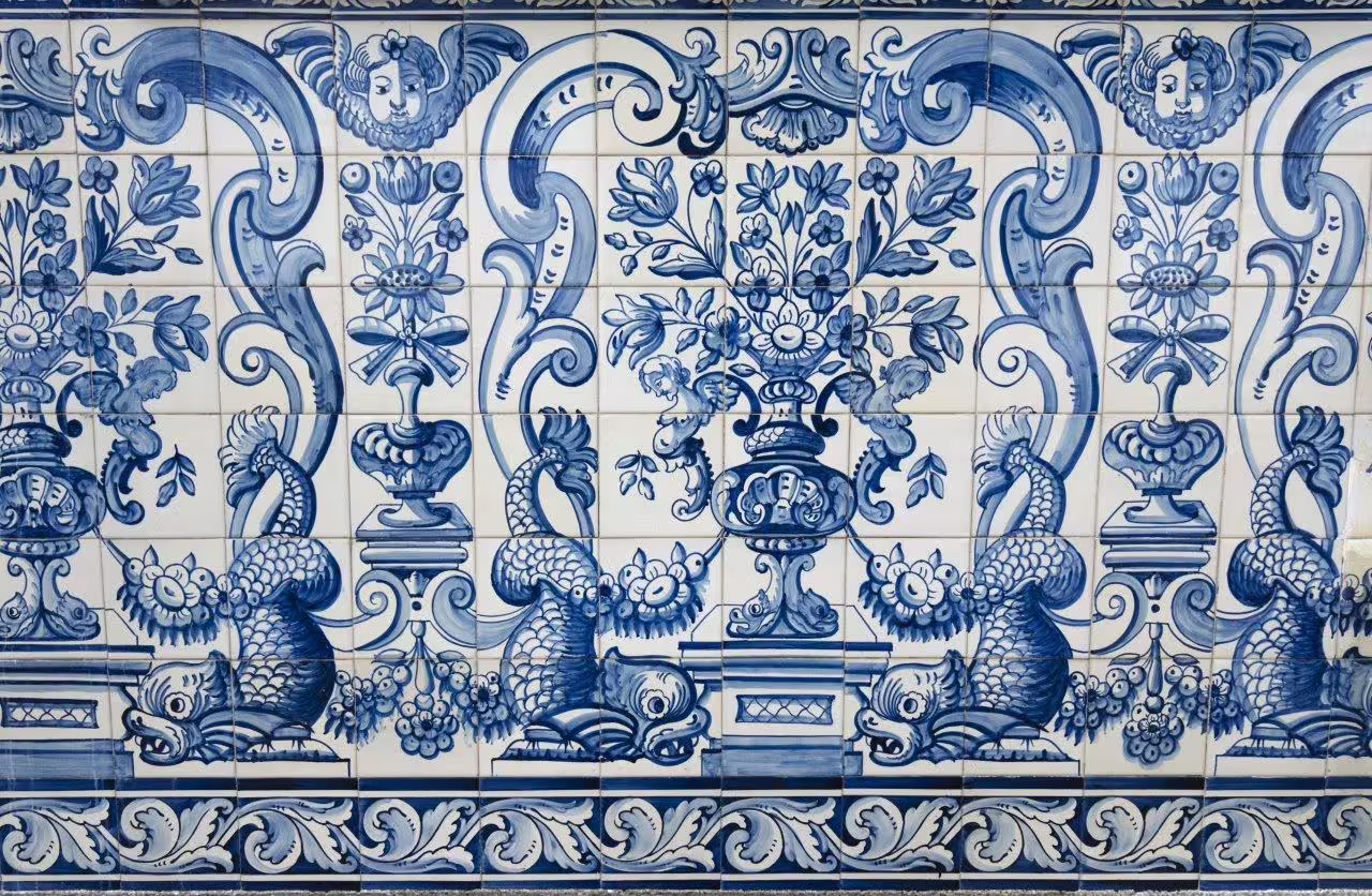 Intricate blue and white azulejo tiles depicting floral and marine motifs, showcasing Portuguese art in Algarve and Alentejo.