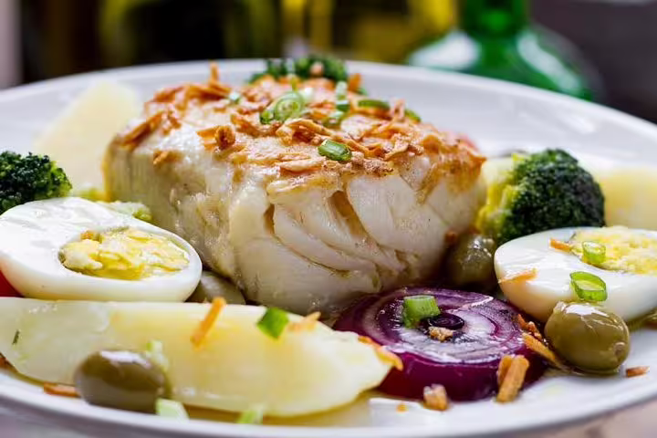 Savor traditional Portuguese bacalhau with boiled eggs and vegetables on the Sintra, Cascais and Pena Palace tour.
