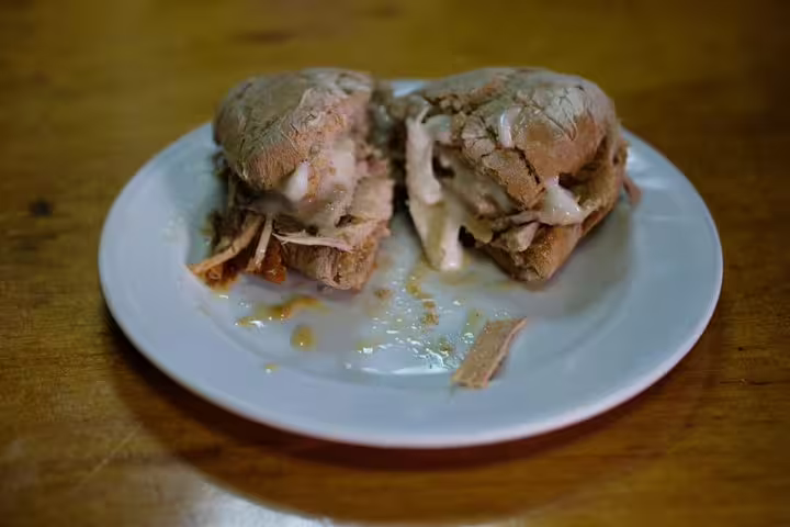 Traditional Portuguese bifana sandwich with tender pork and savory sauce, featured in Porto's Secret Traditional Flavours tour.