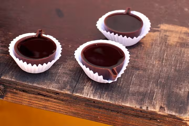 Traditional Portuguese chocolate cups displayed on a rustic wooden table in Óbidos during a private tour.
