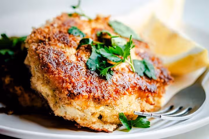 Crispy Portuguese codfish patty garnished with fresh parsley, highlighting Lisbon's culinary delights on the food tour.