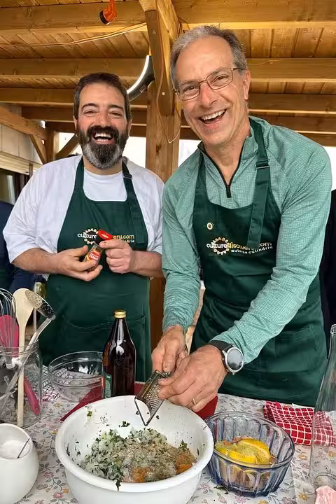 Enthusiastic chefs grating ingredients for a Portuguese dish on a sunny terrace, enhancing a fun cooking class experience.