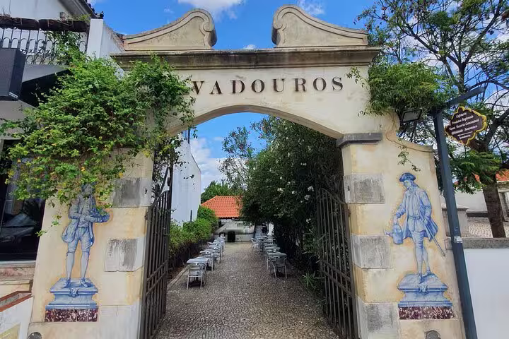 Charming entrance to a traditional Portuguese courtyard in Azeitão, featuring decorative tiles and lush greenery.