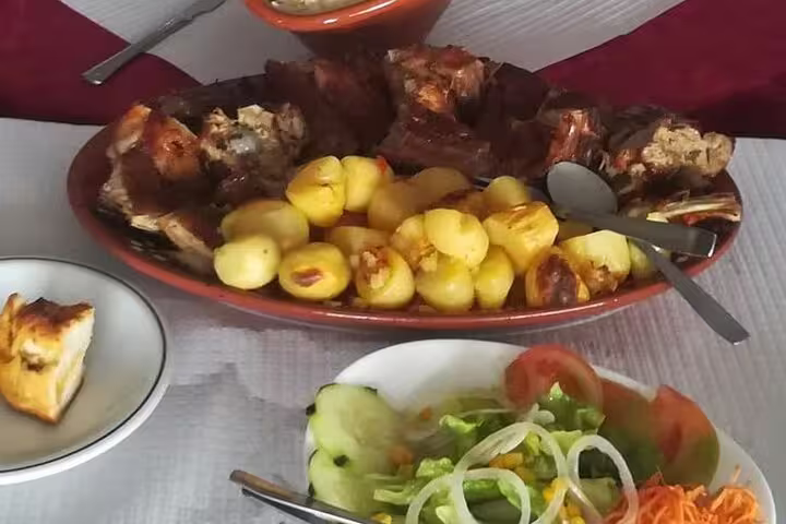 Traditional Portuguese meal with roasted meat, potatoes, and salad on a Douro Valley tour.