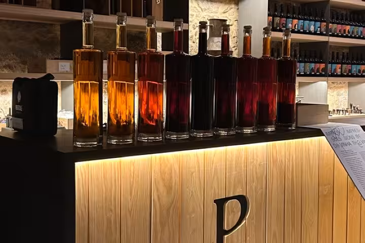 Bottles of Portuguese port lined up at a Porto wine bar, featured tasting on Half Day Porto & Beach Side tour