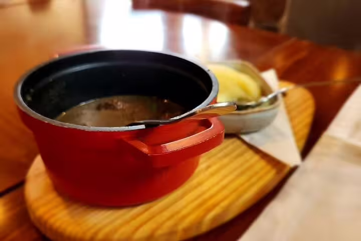 Red pot of traditional Portuguese stew served during the Private Full Day Setúbal & Arrábida Wine Tour with Lunch in Lisbon.