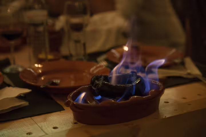 Traditional Portuguese dish with flaming chorizo served during a Fado show in Lisbon, enhancing the cultural dining experience.