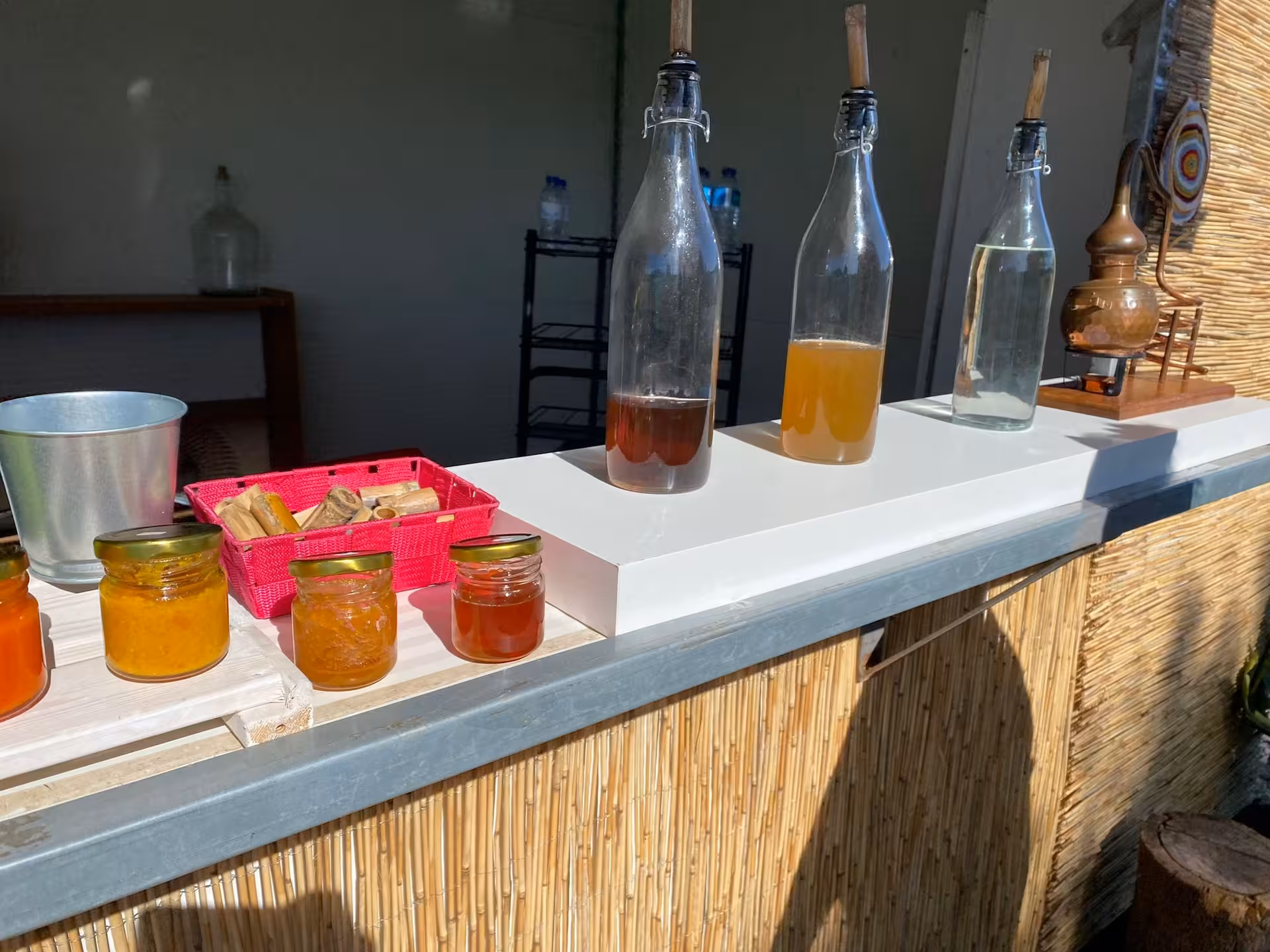 Bottles of local liqueur and artisanal jams on a sunny counter during a Portuguese half day wine tasting experience